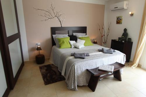 艾姆布里亚布拉瓦LEON INMO Luxusvilla Esmeralda - 10029的一间卧室配有一张带绿色枕头的大床