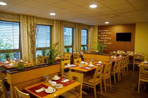 梅特曼艾尔贝尔酒店的一间带木桌和椅子以及黑板的餐厅