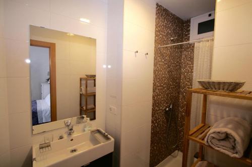 巴塞罗那埃斯帕广场豪华公寓的浴室配有盥洗盆和带镜子的淋浴