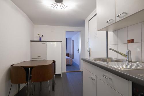 弗里堡Aparthotel Hine Adon Fribourg的厨房配有桌子、水槽和台面