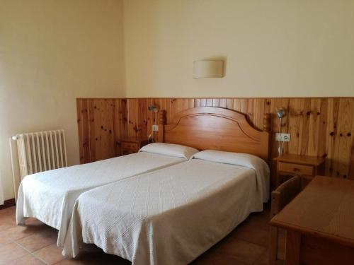 圣洛伦索-德莫鲁尼斯加泰罗尼亚旅馆的一间卧室配有一张带白色床单的大床