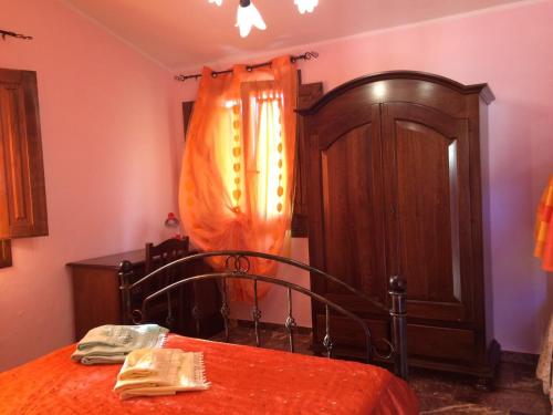 弗卢米尼马焦雷Sa Perda Lada的一间卧室配有一张床和一个木制橱柜