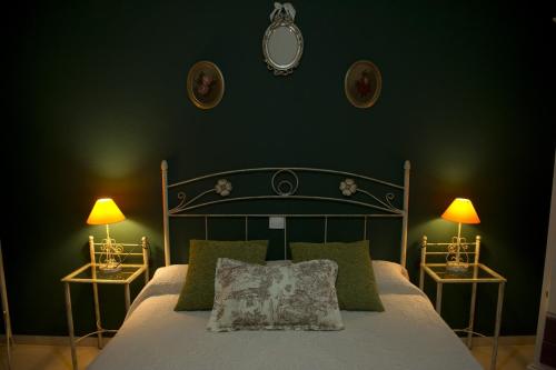 阿尔玛格鲁Casa Rural La Biblioteca的一间卧室配有一张带绿色墙壁的床和两盏灯。