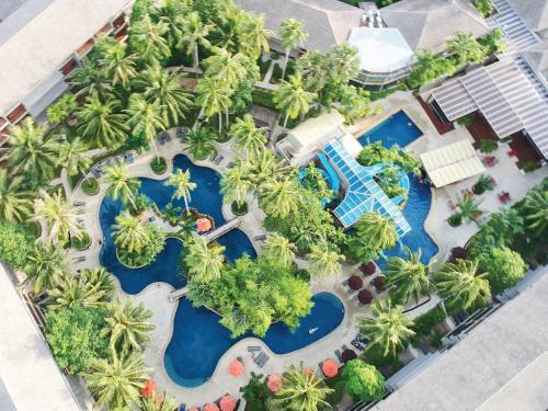 苏林海滩Holiday Inn Resort Phuket Surin Beach, an IHG Hotel的享有棕榈树和游泳池度假村的空中景致