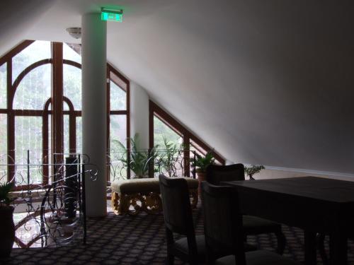 札勒乌Hotel Royal的一间带桌椅和窗户的用餐室