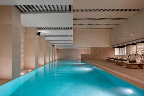 上海新天地朗廷酒店 的大楼内带椅子的大型游泳池