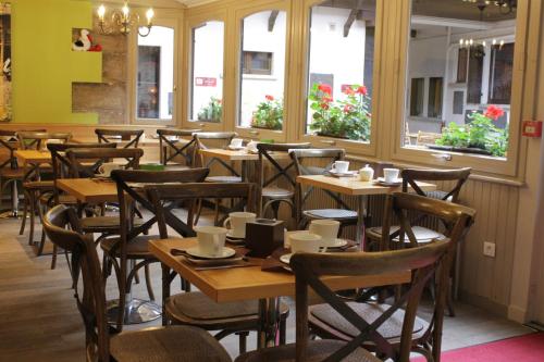 奥贝奈古韦内尔酒店的餐厅设有木桌、椅子和窗户。