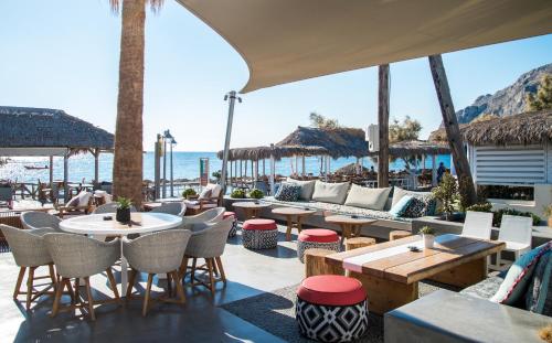 卡马利马克里斯海滩公寓式酒店的一间带桌椅和海滩的餐厅