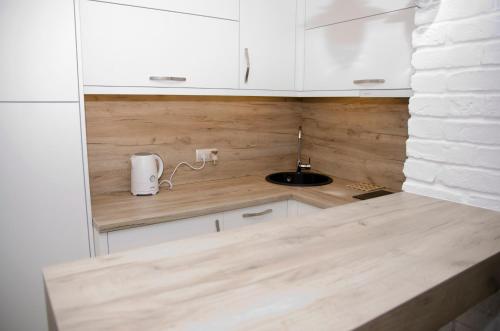 奥尔什丁kameralny apartament的厨房配有白色橱柜和水槽