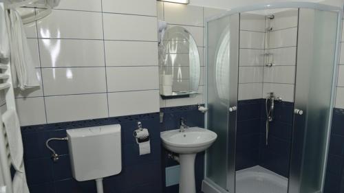 加拉茨Hotel Corneliuss的一间带水槽、卫生间和镜子的浴室