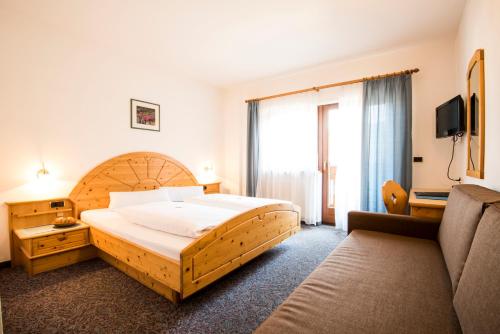 纳兹-夏韦斯Hotel Föhrenhof的一间卧室配有一张大床和一张沙发