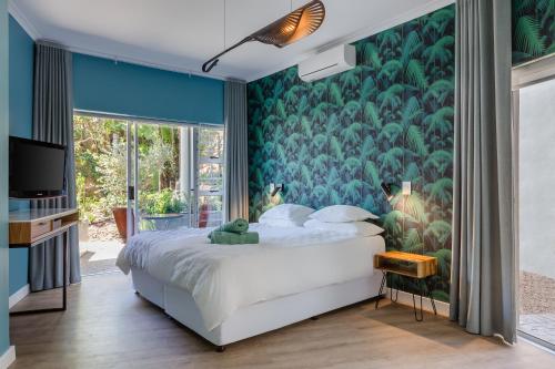 开普敦乐古弗尼尔旅馆的一间卧室配有一张带绿色壁纸的大床