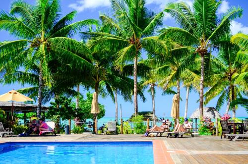 Fuailalo瓦萨度假酒店的棕榈树和游泳池度假村