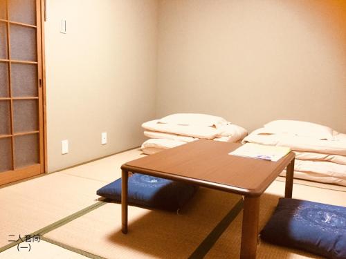 京都京都岚山宾馆的配有桌子和床的房间