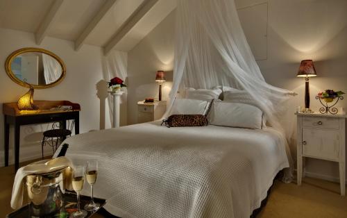 布伦海姆佩普特雷豪华住宿酒店的一间卧室配有一张带天蓬的白色床