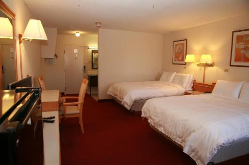 斯威夫特卡伦特Widus Inn的酒店客房设有两张床和一张桌子。