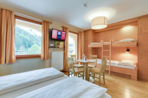 Veitsch法伊奇JUFA宾馆的一间卧室配有两张床、一张桌子和一张双层床。