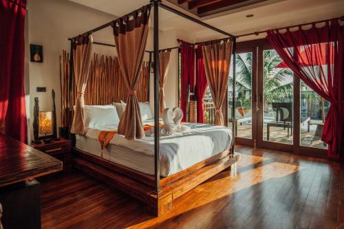 高兰泰国海岛梦想庄园酒店的一间卧室设有一张天蓬床和一个阳台