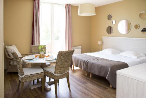 阿卡雄Résidence de Tourisme Vacances Bleues Villa Regina的卧室配有一张床和一张桌子及椅子