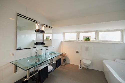哈林亨Harlingen oldtown apartment的一间带两个盥洗盆、浴缸和卫生间的浴室