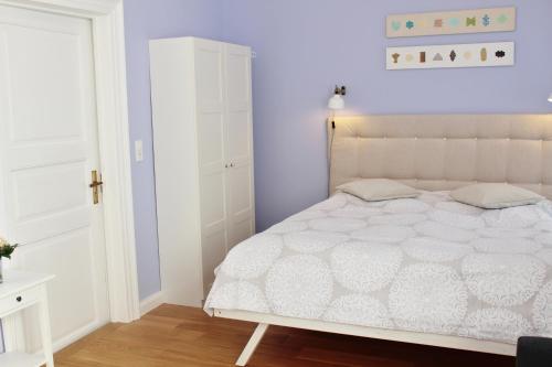 不莱梅Apartment Flieder Zentral的卧室配有白色的床和白色橱柜