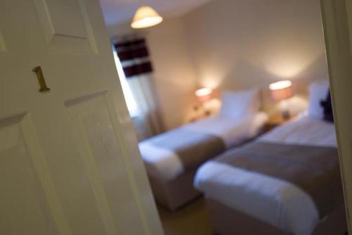 比尔斯韦尔斯The Roast Ox Inn的酒店客房设有两张床和窗户。