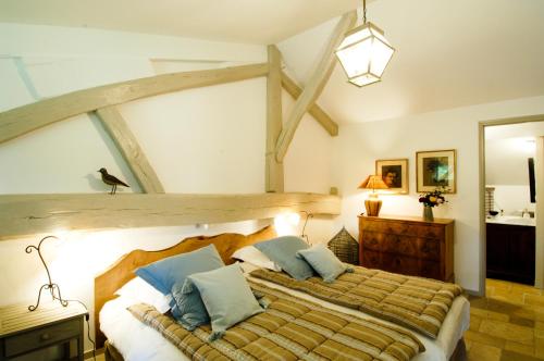布拉列玛丽欧仁妮农场酒店的一间卧室配有一张带蓝色枕头的大型木制床。