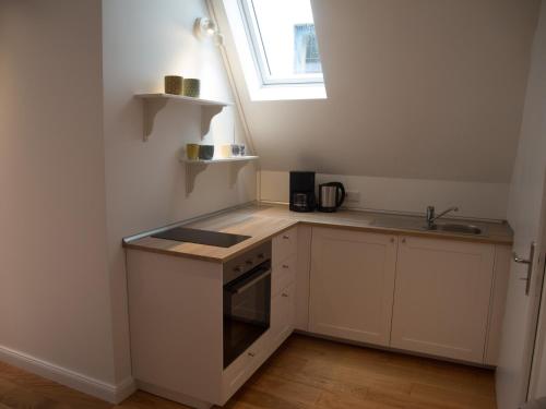 不莱梅Schönes Studio zentral的白色的小厨房,配有水槽和窗户