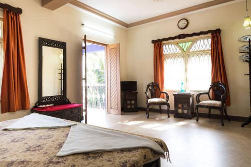瓦斯科达伽马The Pereira's Goan Homestay Villa的一间卧室配有一张床、镜子和一张书桌