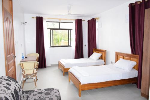 姆特瓦帕Mawenzi Resort -Mtwapa的客房设有两张床、一把椅子和窗户。
