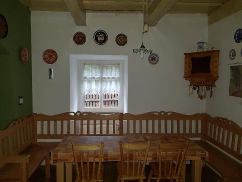 斯泰尔霍伊Chalupa U Potoka的一间带木桌和椅子的用餐室
