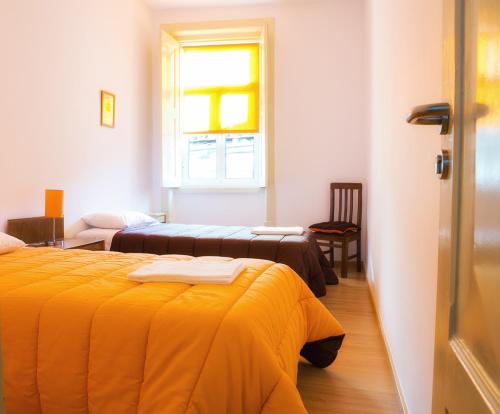 科英布拉橄榄街公寓的酒店客房设有两张床和窗户。
