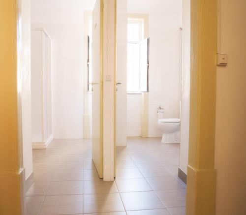 科英布拉橄榄街公寓的一间带卫生间的浴室和一个带门的走廊