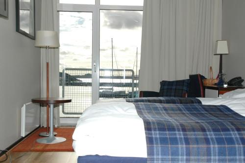 Tananger胡木尔伦酒店的一间卧室设有一张床和一个大窗户
