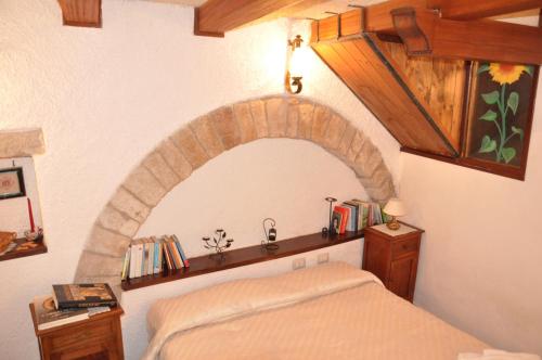 阿西西Da Marzietta的一间卧室配有一张位于上面的石拱床。