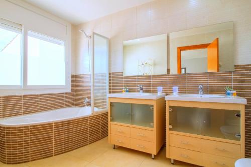 艾姆布里亚布拉瓦LEON INMO Luxusvilla Coral - 10190的浴室配有两个盥洗盆、浴缸和浴缸。