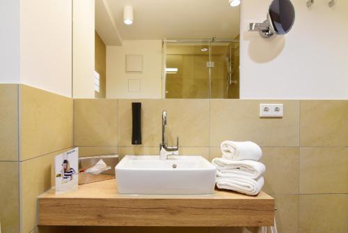 Wolframs-Eschenbach阿尔特沃格泰酒店的一间带水槽和台面毛巾的浴室
