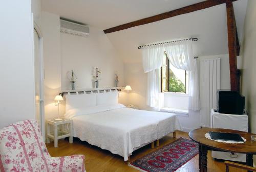 BelcastelLe Vieux Pont的卧室配有白色的床、桌子和椅子