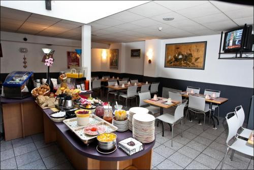 科尔马Hotel Primo Colmar Centre的用餐室配有餐桌和食物