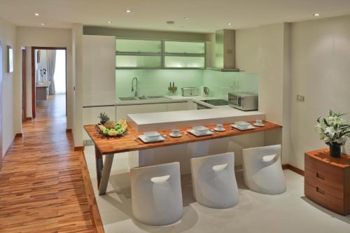 波普托奥修豪华公寓的厨房配有带4把白色椅子的台面