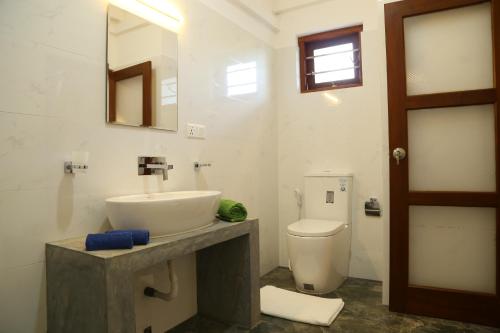 希克杜沃Hikka Regent Hotel的一间带水槽、卫生间和镜子的浴室