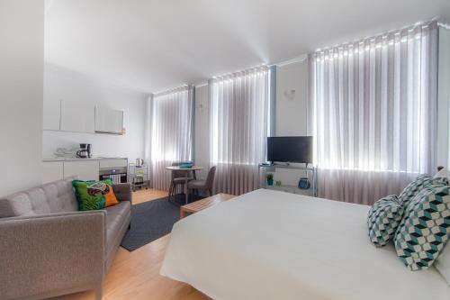 波尔图卡里祖城市休闲公寓的一间卧室配有一张床、一张沙发和一张桌子