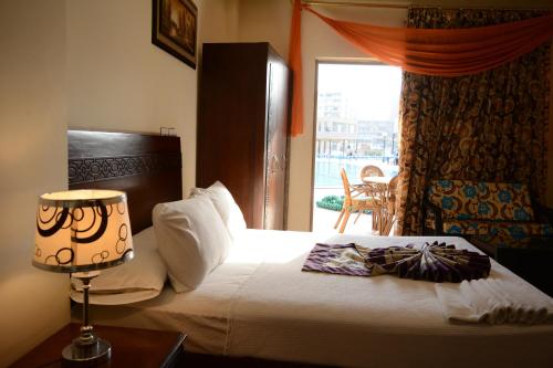开罗Jewel Glorious Hotel的一间卧室配有一张带灯和窗户的床