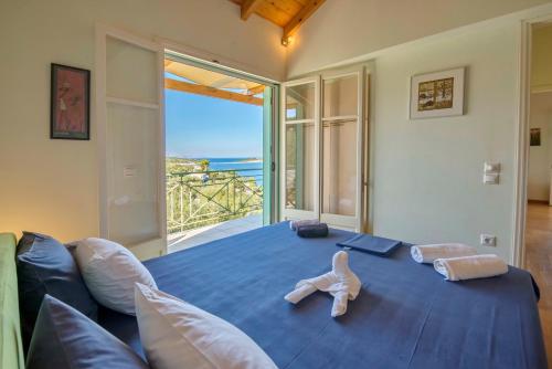 盖奥斯Villa Manti的一间享有海景的卧室,配有一张蓝色的床