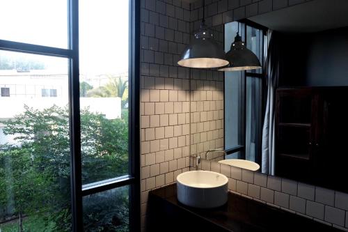 清迈古色古香清迈酒店的一间带水槽和镜子的浴室以及窗户。