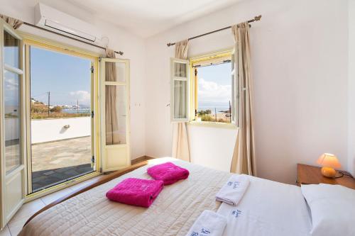 洛加拉斯Villa San Dimitrio House on the Beach的一间卧室配有一张带两个粉红色枕头的床