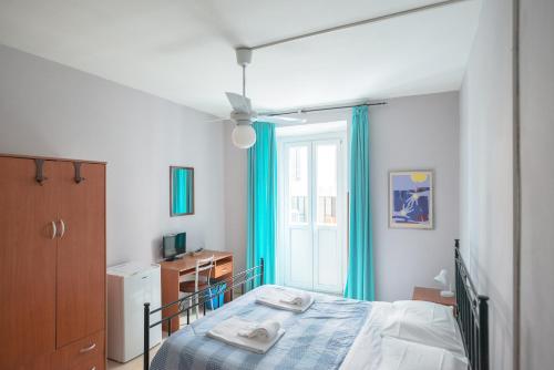 罗马加尔勒尔B＆B酒店的一间卧室配有一张带蓝色窗帘的床和一扇窗户
