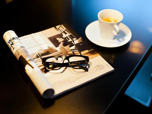 格丁尼亚Apartamenty Modern Gdynia的书,眼镜,桌上的咖啡