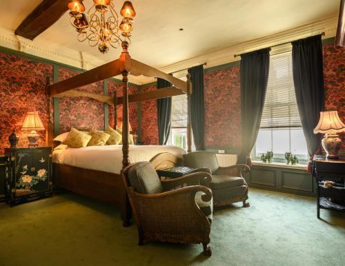 朴次茅斯耶斑点狗旅馆的一间卧室配有一张床、一把椅子和一个吊灯。