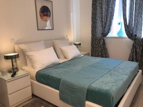 尼斯坎迪尔公寓的一间卧室配有一张带蓝色毯子的床